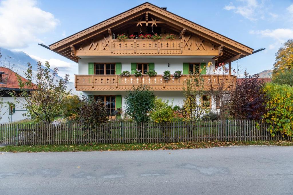 a house with a balcony on top of a fence at Fewo Maria Grasegger in Grainau