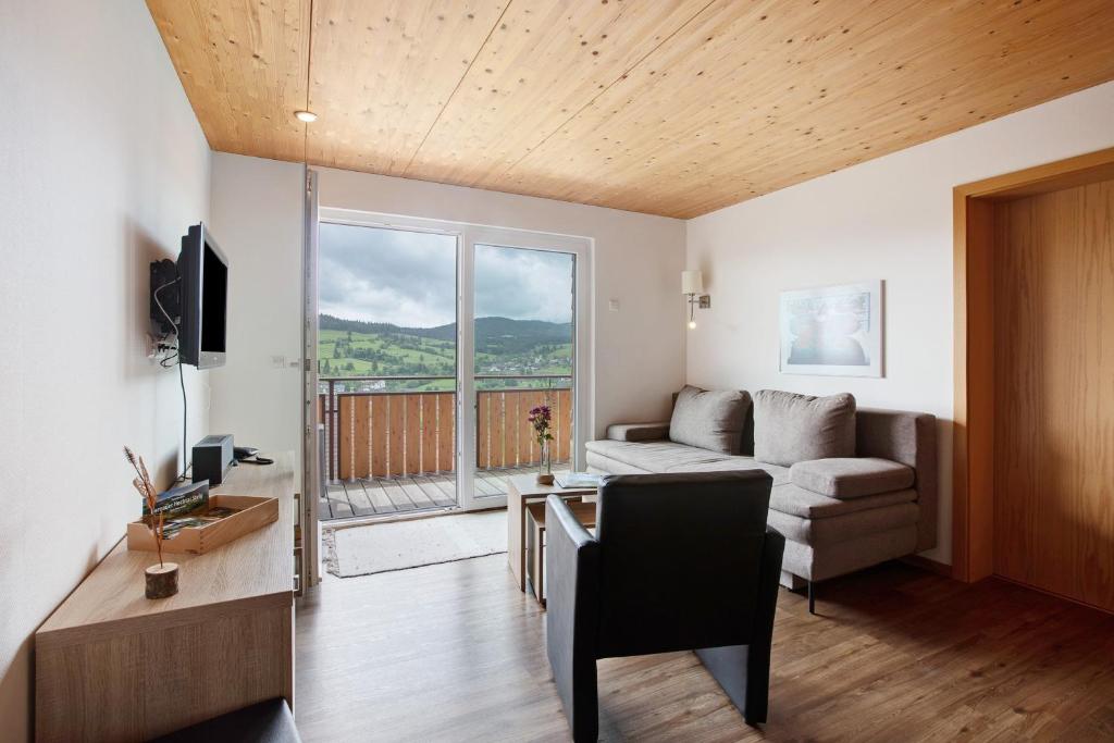 a living room with a couch and a large window at Ferienwohnung Blösling 2 in Bernau im Schwarzwald