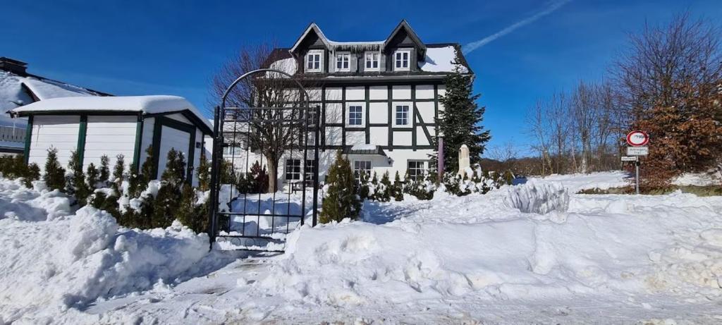a large house is covered in snow at Fachwerkhaus Korntenne in Eimelrod