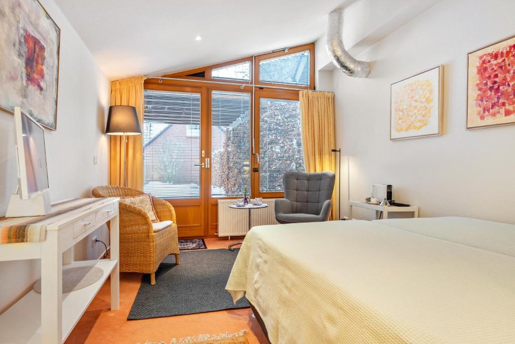 a bedroom with a bed and a chair and a window at room4you in Hemmingen