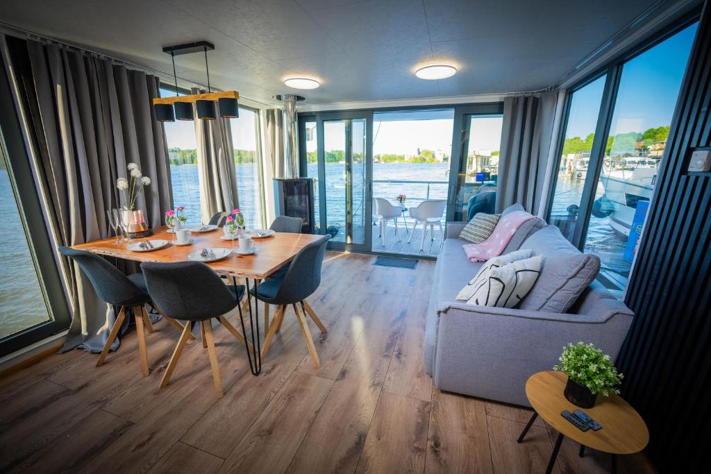 a living room with a table and a couch at Luxuriöses Hausboot Roma Woma D13 in Fürstenberg