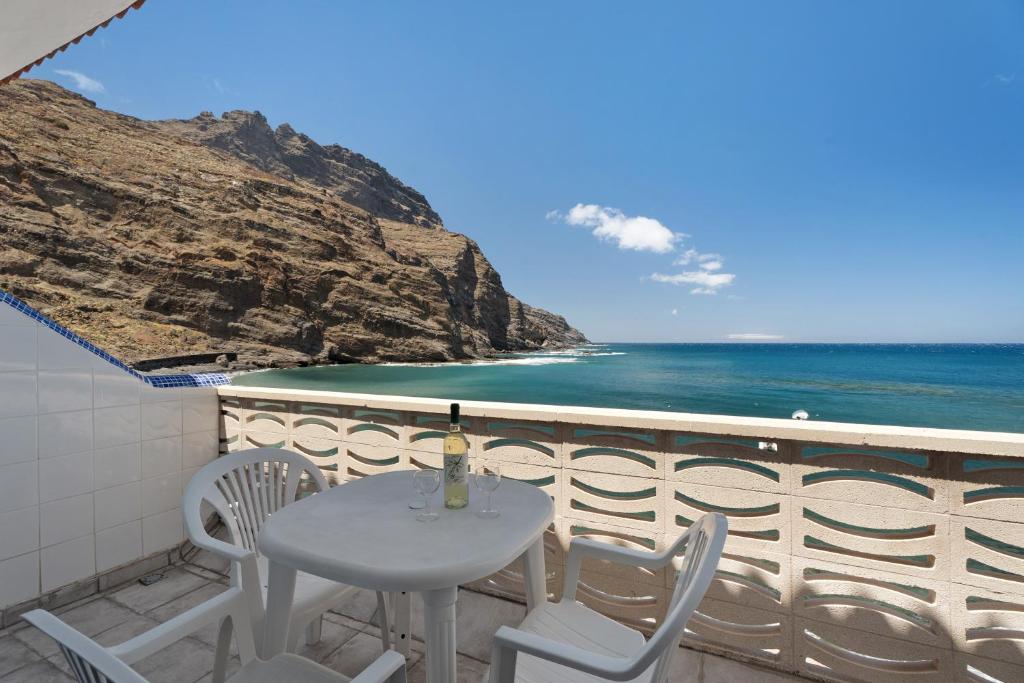a table and chairs on a balcony overlooking the ocean at Apartamentos Playa Azul - 8 in Vallehermoso