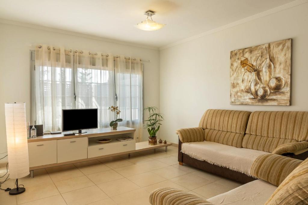a living room with a couch and a flat screen tv at Duplex Pedroza in Pozo Izquierdo