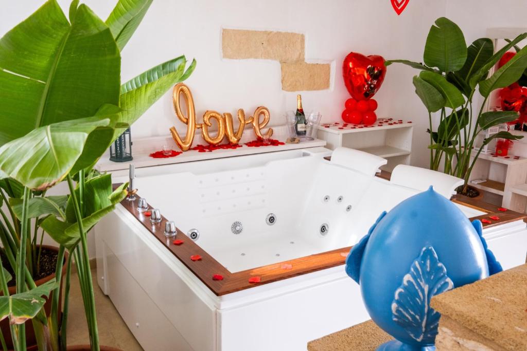 a bath tub in a room with plants at Nuvò-Lux e Spa in Veglie