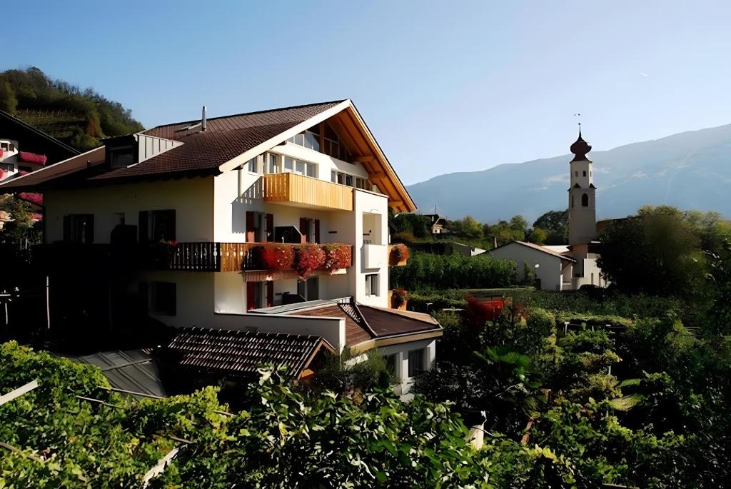 a white building with a lighthouse in the background at Garni Unterweggütl in Naturno