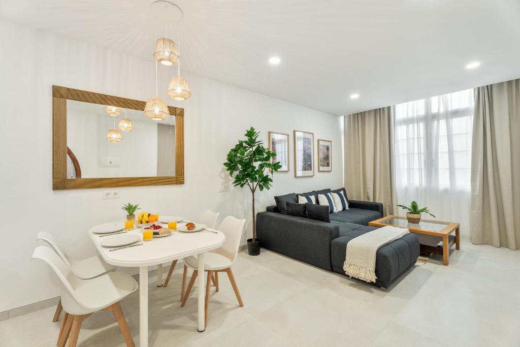 a living room with a couch and a table at Sunlit Modern Stay in Arona