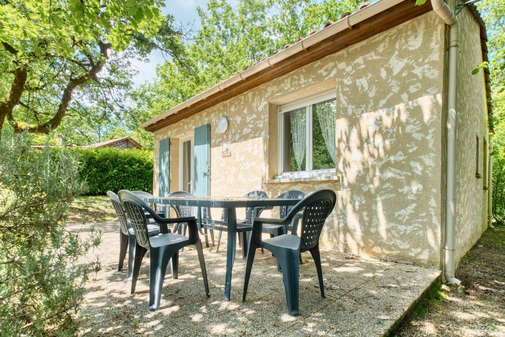 a table and chairs outside of a building at Gite Girolle in Salignac Eyvigues