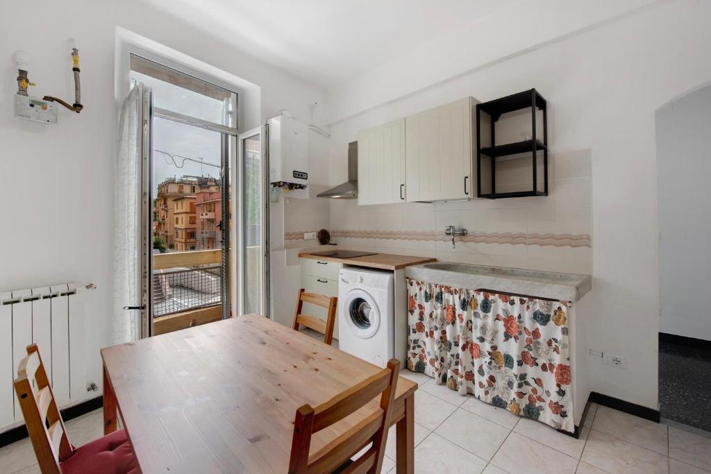 eine Küche mit einem Tisch und einer Waschmaschine in der Unterkunft Casa Rostan in Genua