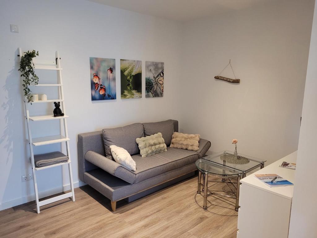 a living room with a couch and a glass table at Rike in Oesterdeichstrich