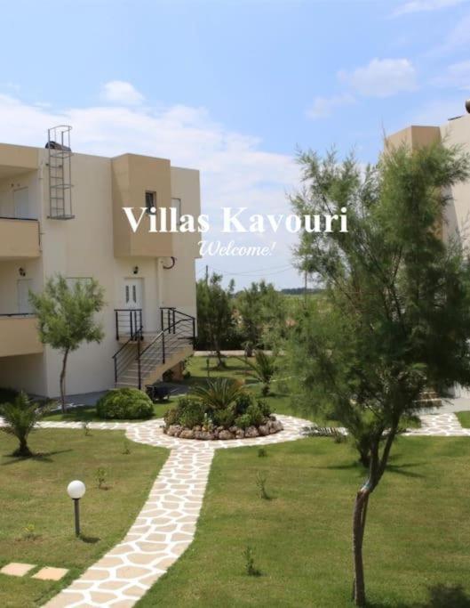 a building with a walkway in front of a yard at Villas Kavouri in Kryonéri