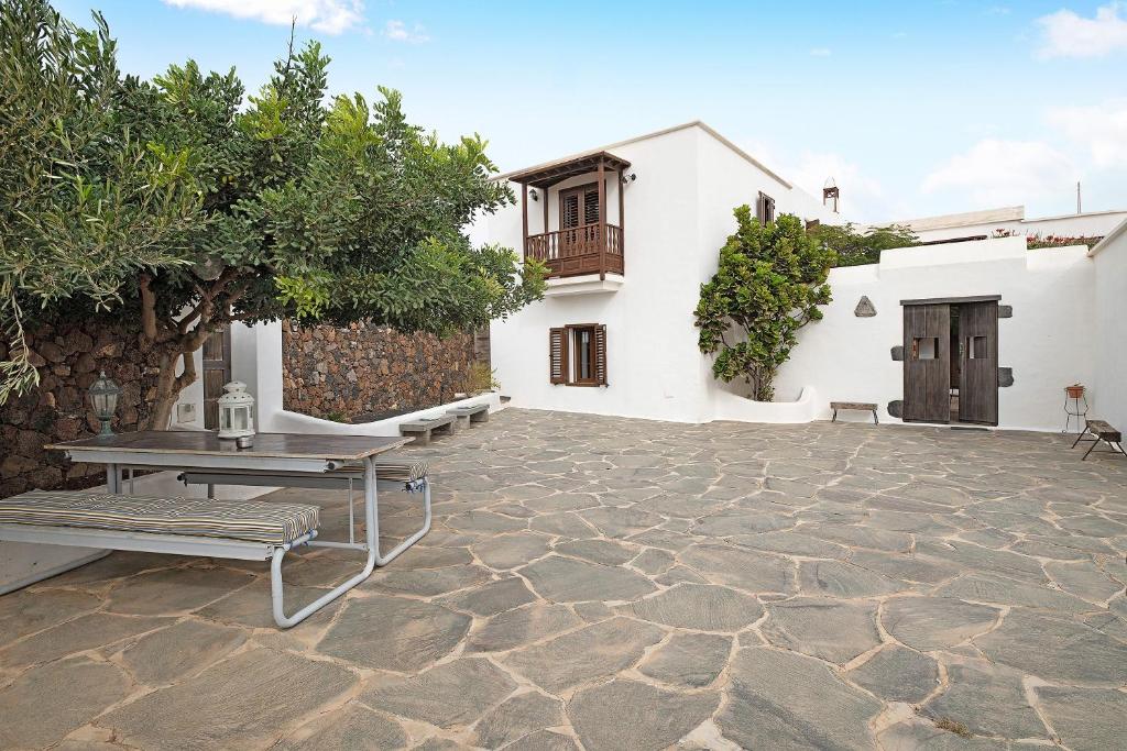 a patio with a bench and a table and a building at La Escuelita in Los Valles