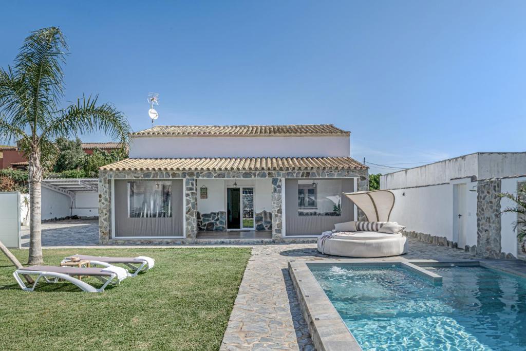 a villa with a swimming pool and a house at Casa El Buda in Vejer de la Frontera