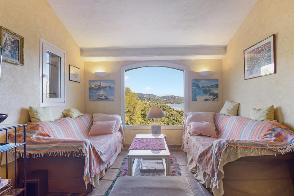 a living room with two couches and a window at Villa - La Mignonette avec terrasse in Cavalaire-sur-Mer