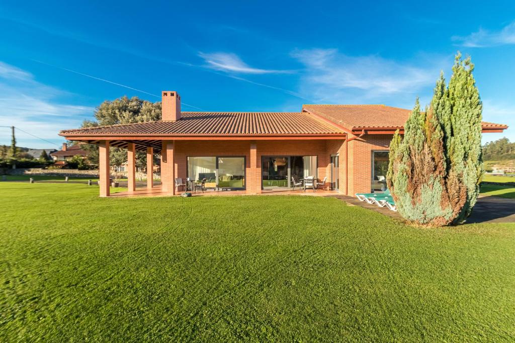 a house with a large lawn in front of it at Villa Monasterio in Camargo