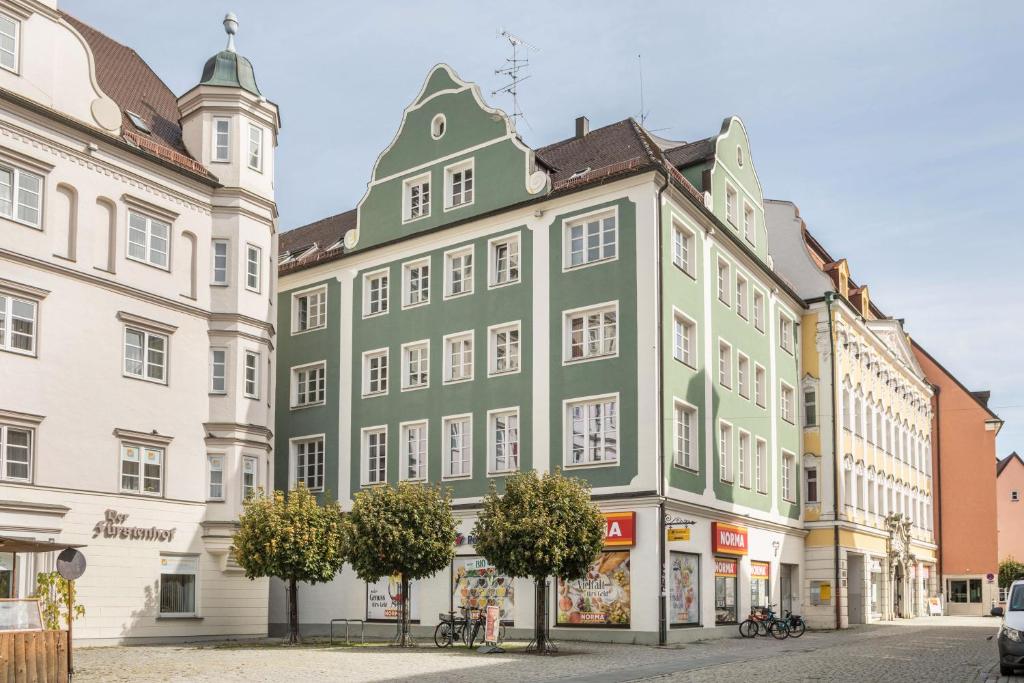 a green building next to two white buildings at Appartement Rathausplatz in Kempten