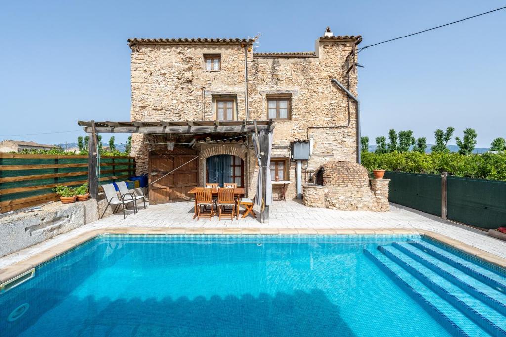 a villa with a swimming pool in front of a building at Lo Molí de la Jòrdia in Tortosa