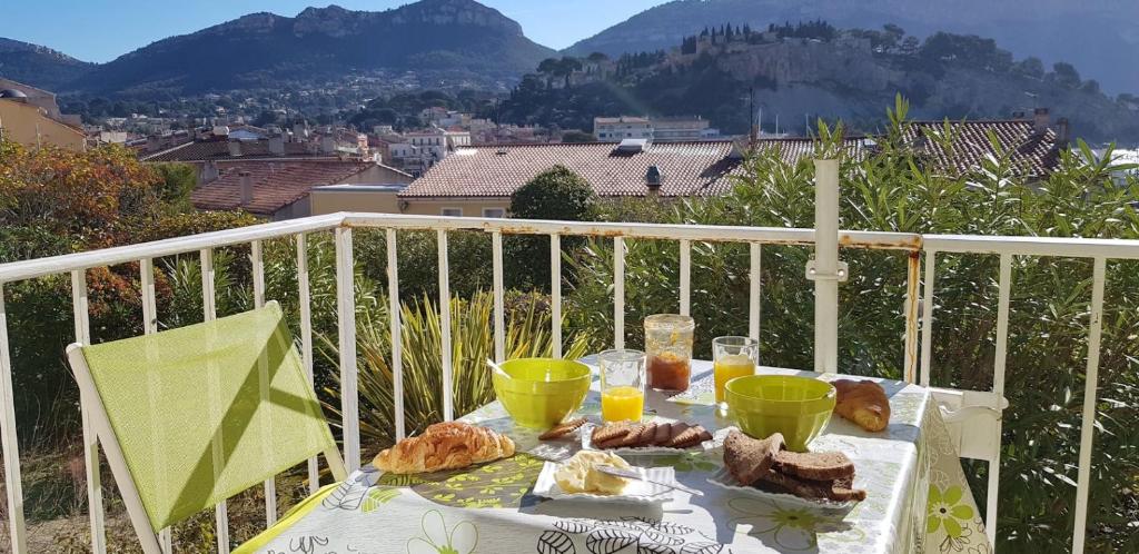 a table with bread and drinks on a balcony at T2 Le Bougainvillier Cassis in Cassis