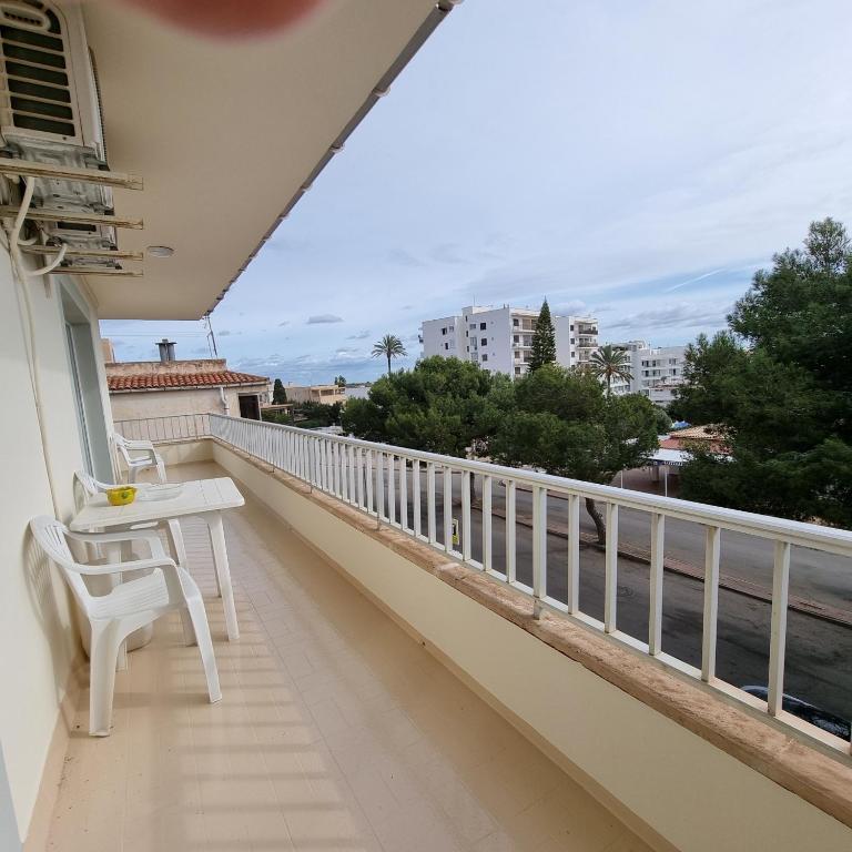 a balcony with a white chair and a view of the water at Apartamento Portosun Estrella in Portocolom