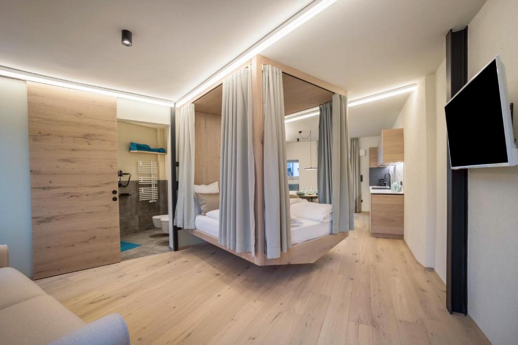 a bedroom with a bed and a tv in a room at Avia Living Teresa in Brunico