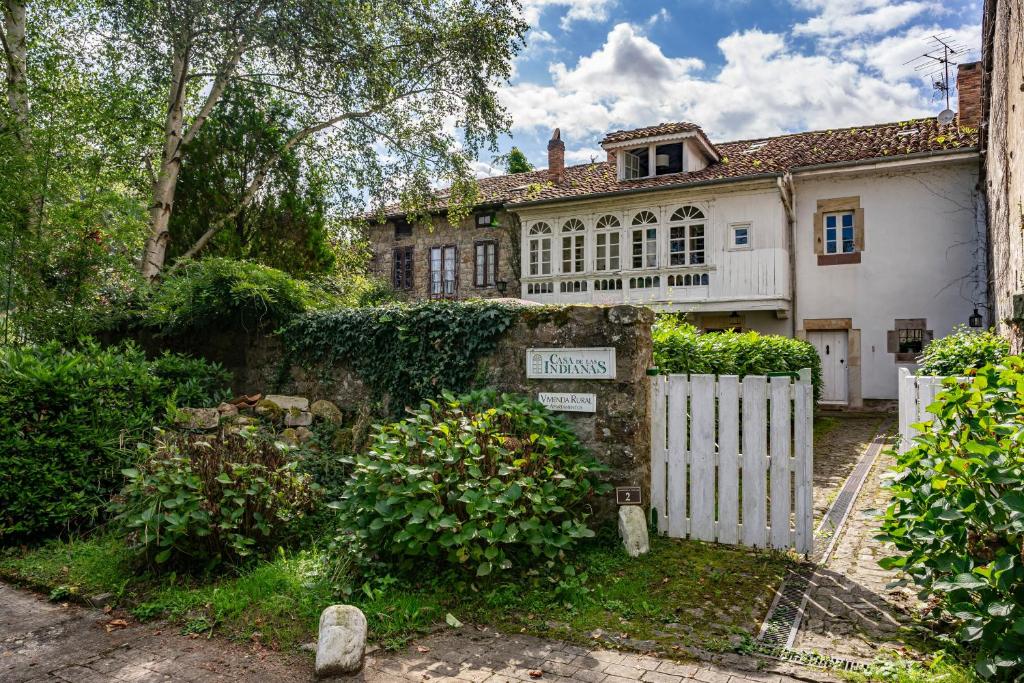 a white fence in front of a house at Apartamento 4 Casa Las Indianas in Selores