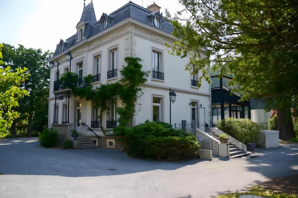 a large white house with a large driveway at Maison Bourgeoise de caractère in Tarare