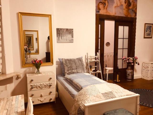 a bedroom with a bed and a dresser and a mirror at Pension Nazli Elmshorn in Elmshorn