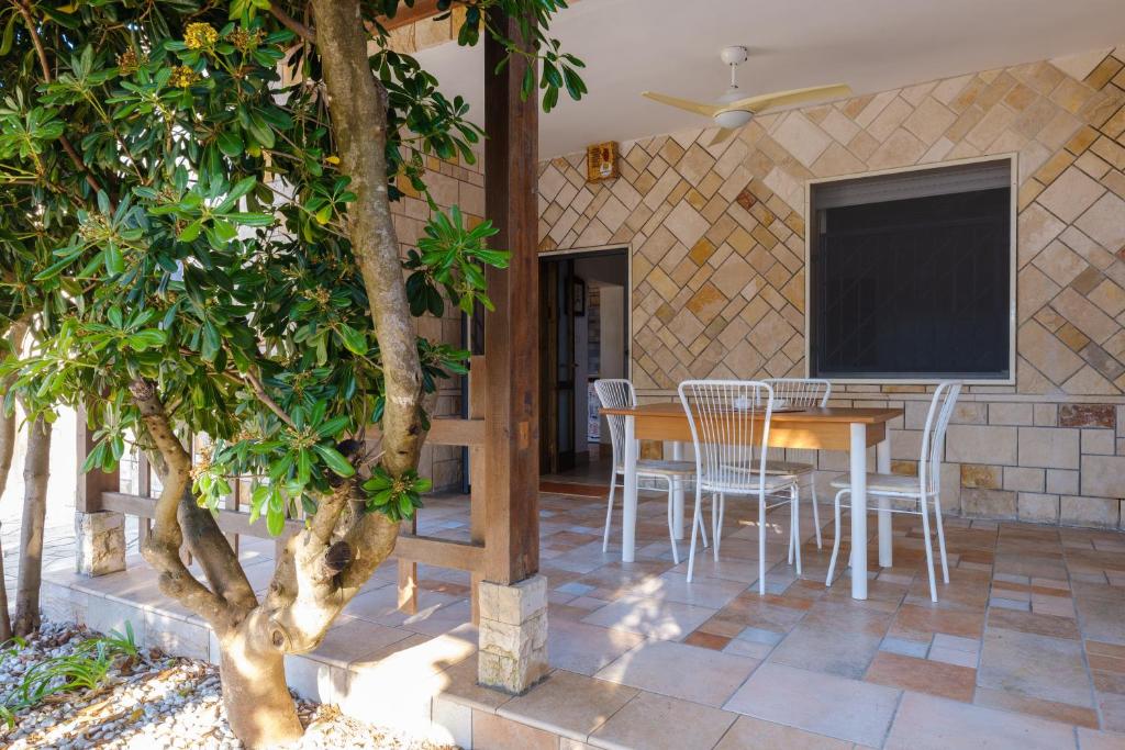 a patio with a table and chairs and a tv at Villa Assunta in Lecce