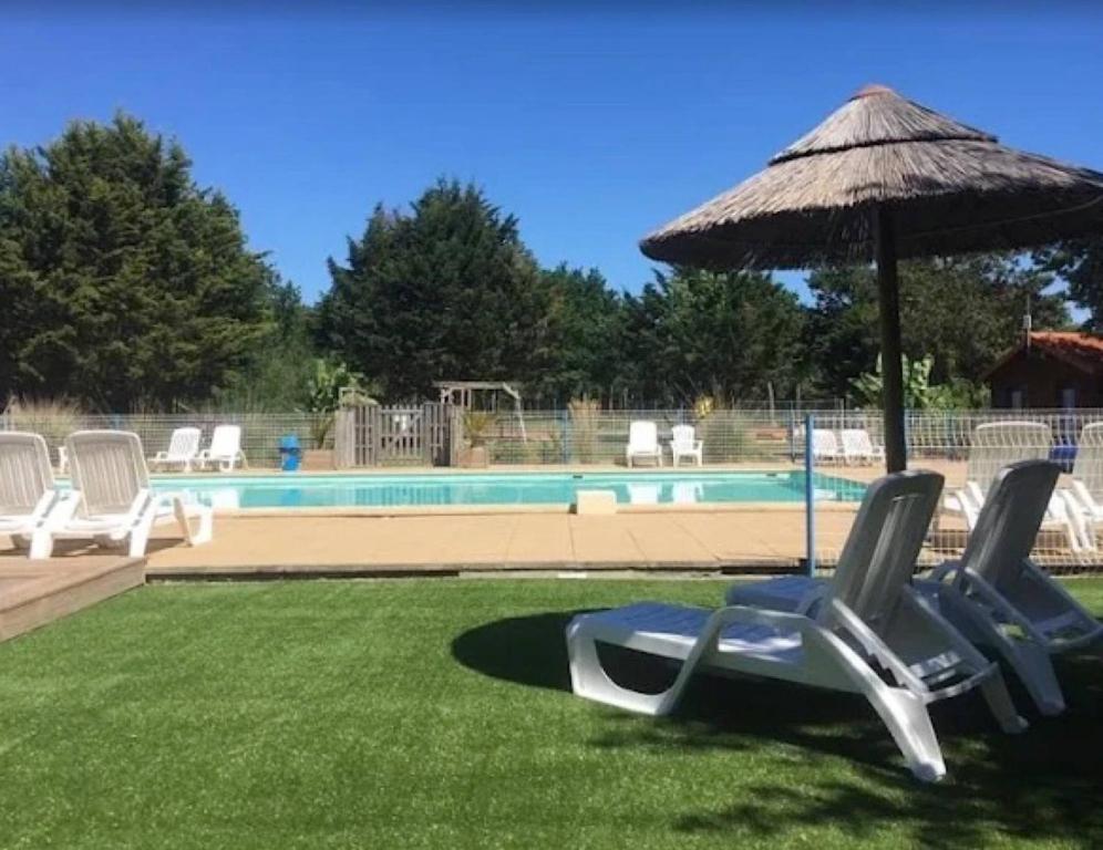 a group of chairs and an umbrella next to a pool at Chalet confort 11 in Saint-Gervais