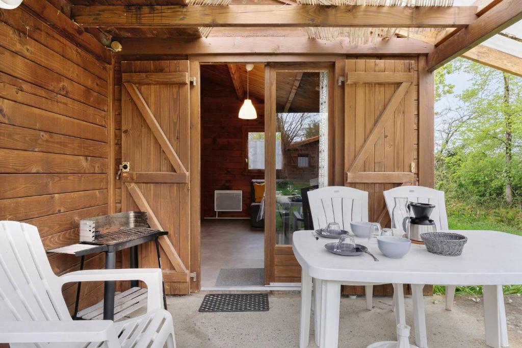a wooden cabin with a white table and chairs at Chalet confort 10 in Saint-Gervais