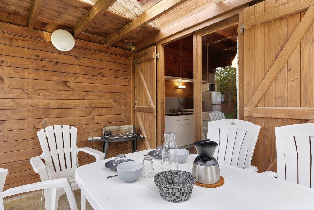 a dining room with a table and white chairs at Chalet confort 2 in Saint-Gervais