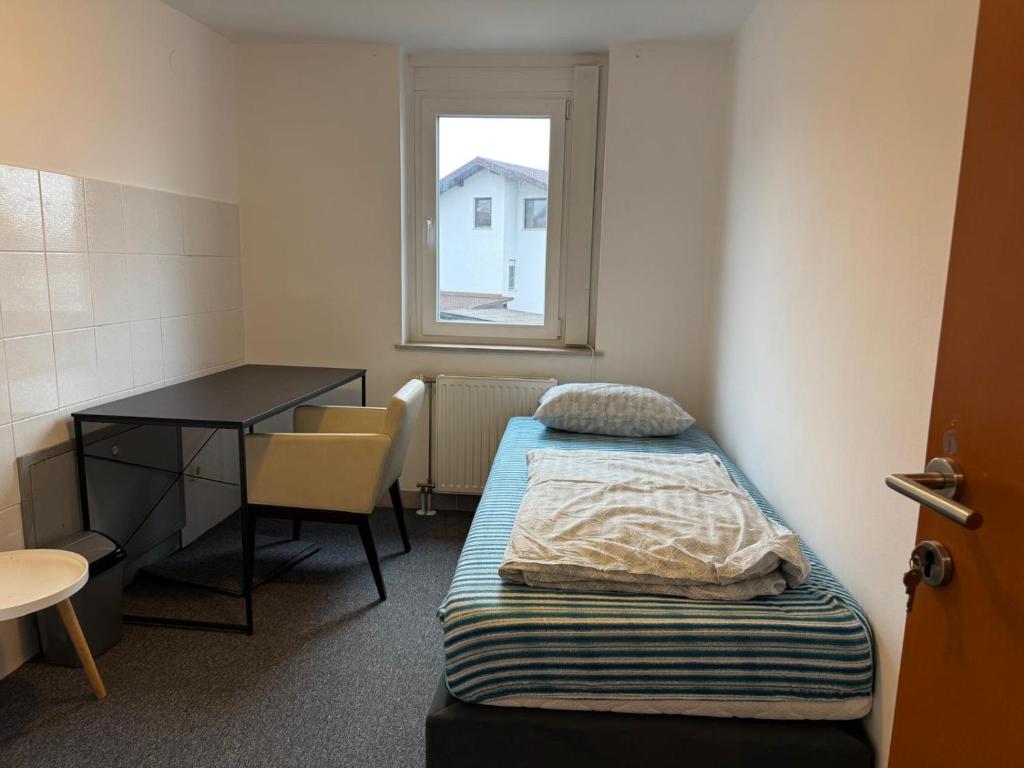 a room with two beds and a desk and a window at Spacious Rooms Near Center in Ljubljana