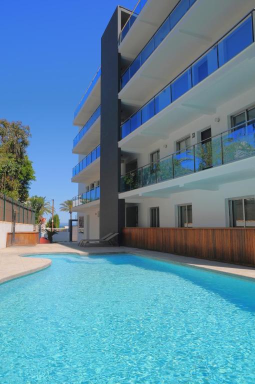 a swimming pool in front of a building at Apartamentos Bravosol in Denia
