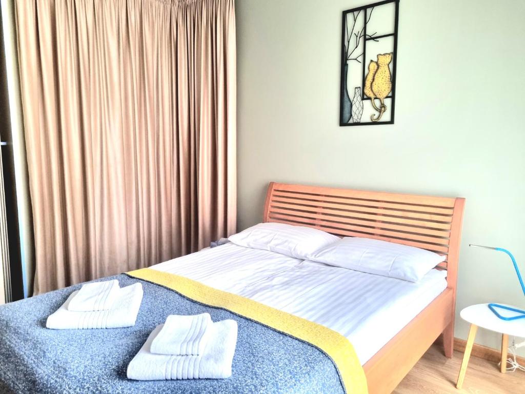 a bedroom with a bed with two towels on it at GMM Namai in Palanga