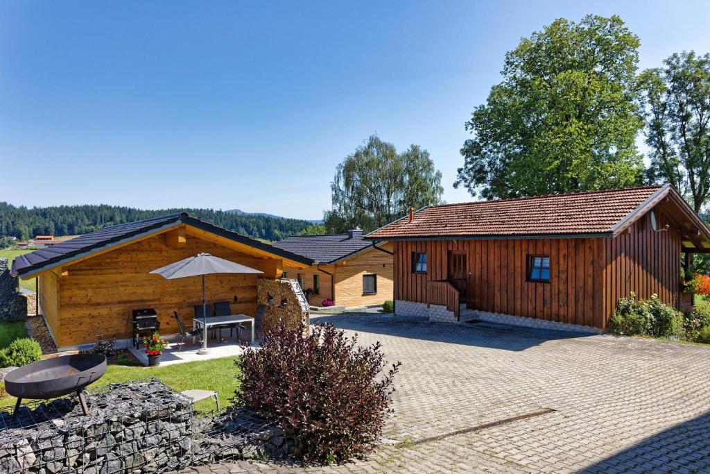 a log cabin with a patio and a grill at Ferienhaus Breit in Eppenschlag