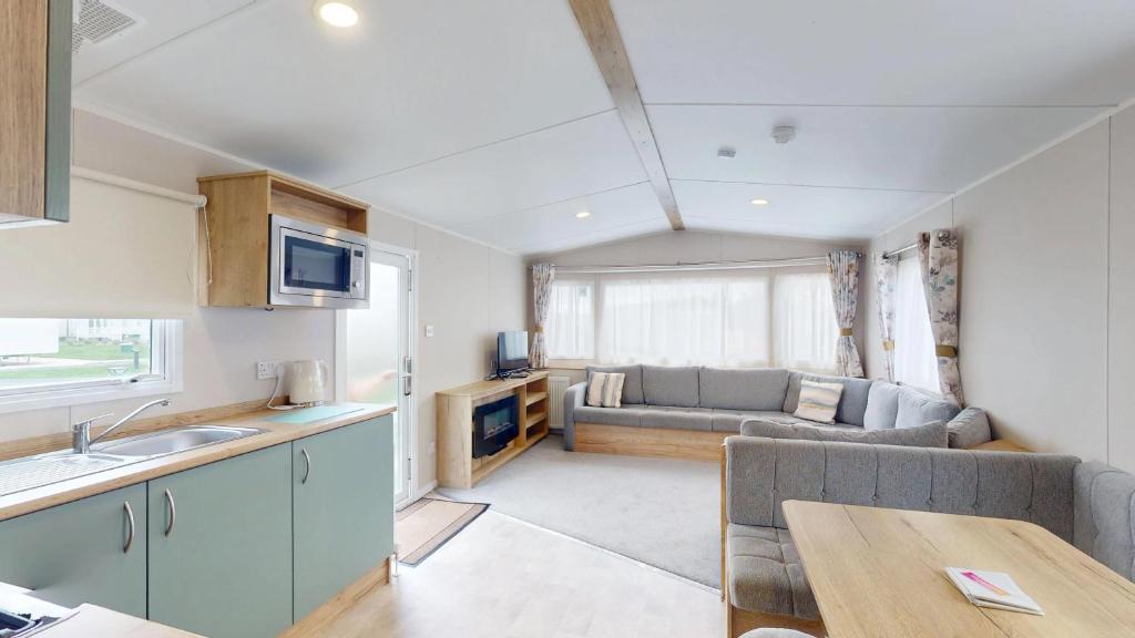a kitchen and living room with a couch and a table at Unity Seven Lakes in Crowle