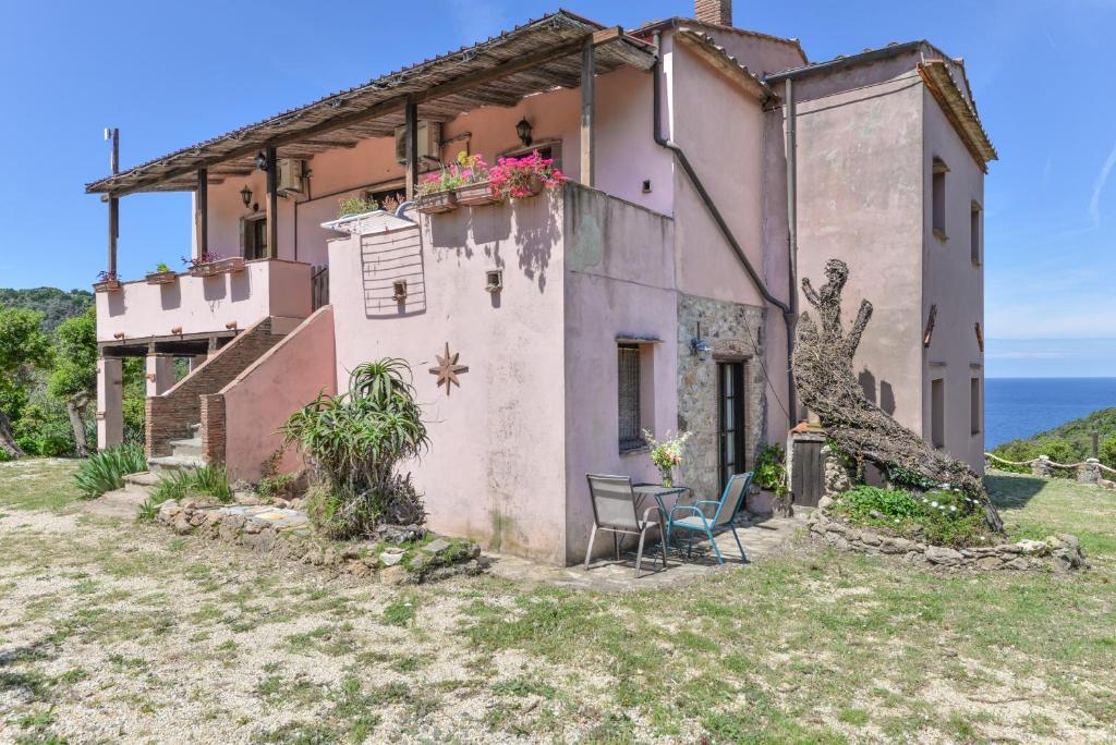 an old house on the hill with a table and chairs at Agriturismo Amandolo in Cavo