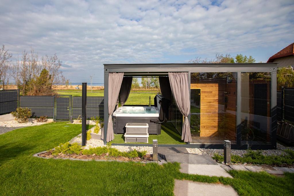 a gazebo with a tub in a yard at Pelso Lodge Alsóörs in Alsóörs