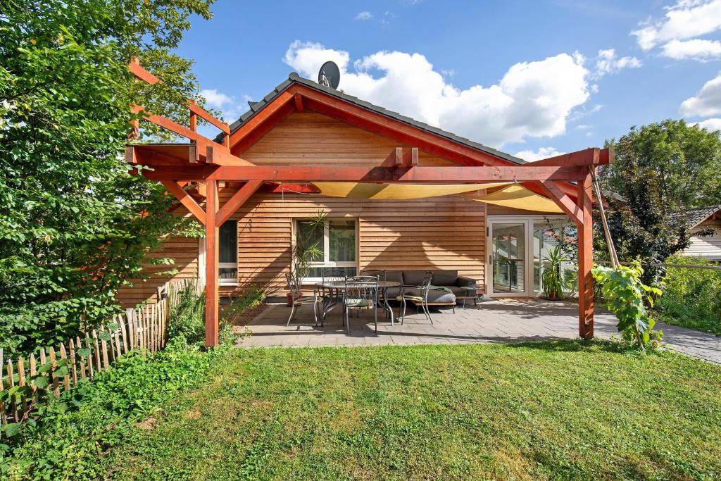 a wooden pergola with a table and chairs on a patio at Leben am Weinberg in Herbstein