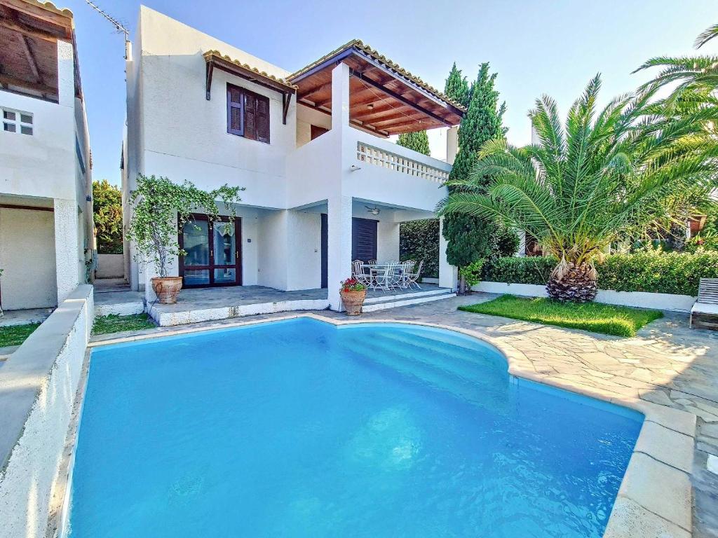 a swimming pool in front of a house at Beach Villa, Swimming pool for 8 in Thermisía