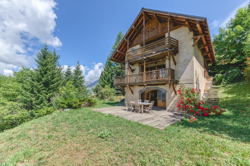 a house with a balcony and a table and chairs at Gabbro-Chalet Moderne Tout Confort in Villard-Reculas