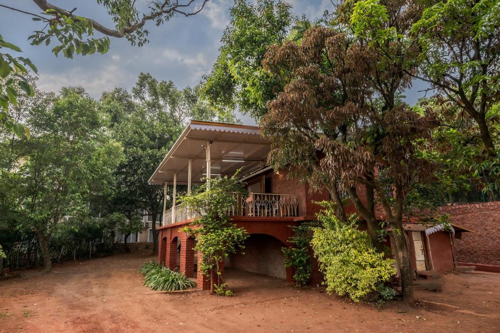 a house with a balcony on a dirt road at SaffronStays Sparrow's Nest in Mahabaleshwar