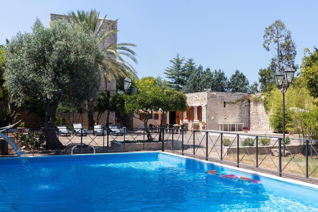 a blue swimming pool in front of a house at Torre Cappavecchia in Molfetta