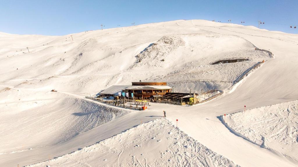 a building on top of a snow covered mountain at Rossalm in Brixen