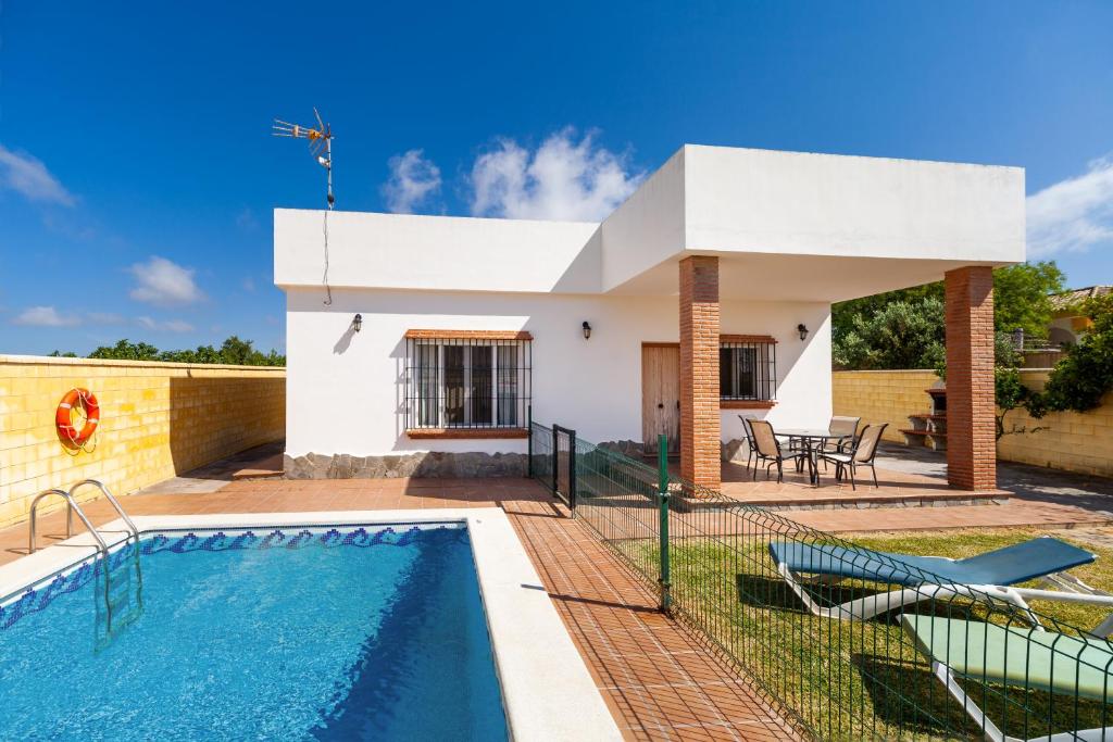 a villa with a swimming pool and a house at Luisa 3 in Conil de la Frontera
