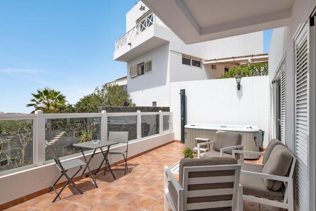 a balcony with a table and chairs and a view of the ocean at Garden Apartment in Tías