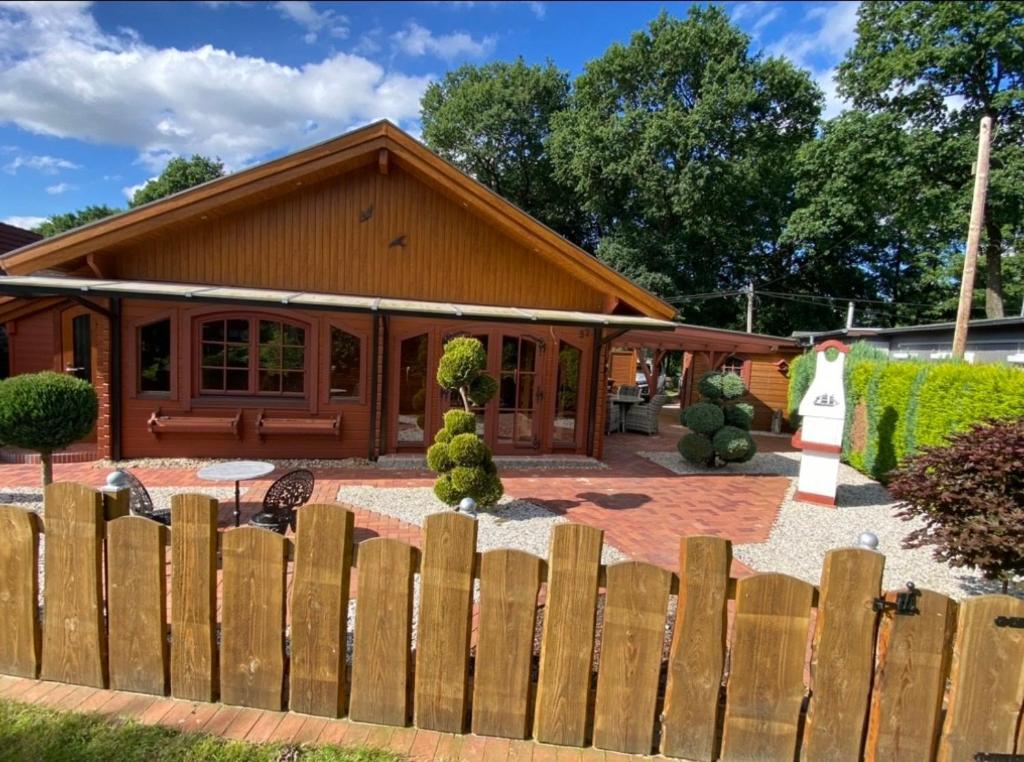a house with a wooden fence in front of it at Idylle Ferienhaus Ems in Walchum