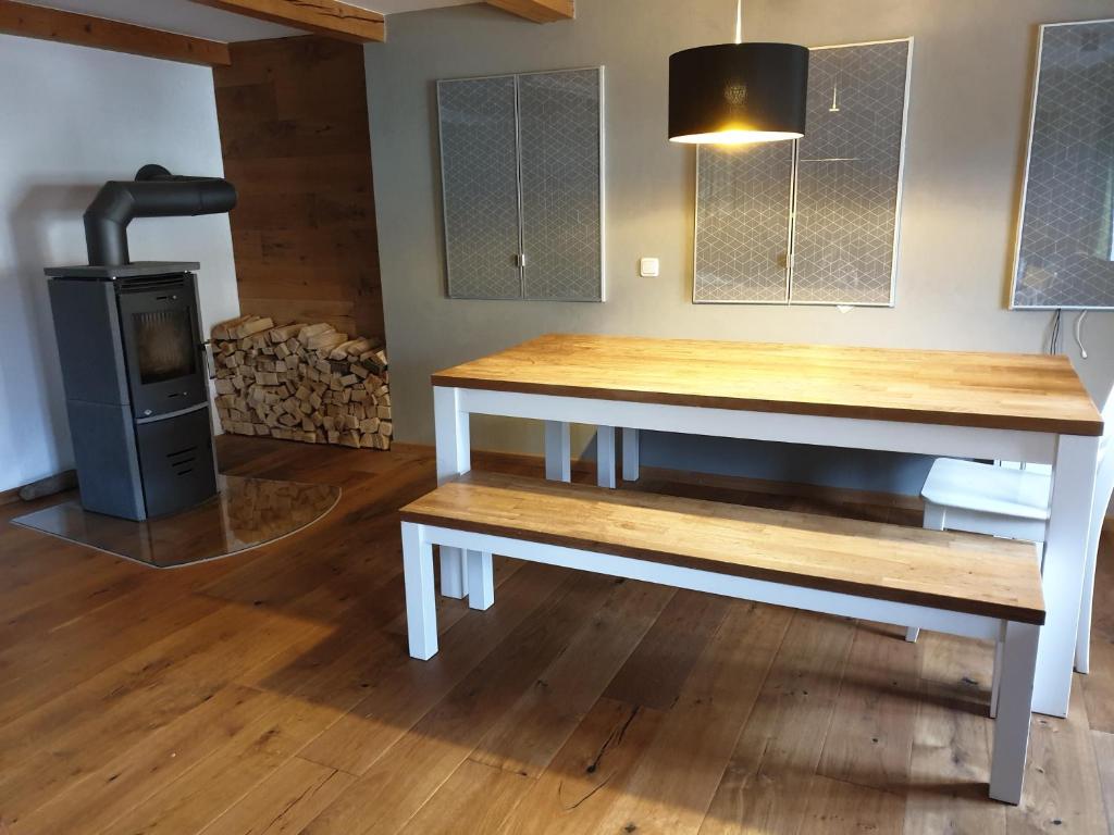 a table and bench in a room with a wood stove at Den Bergen Ganz Nah in Pfronten