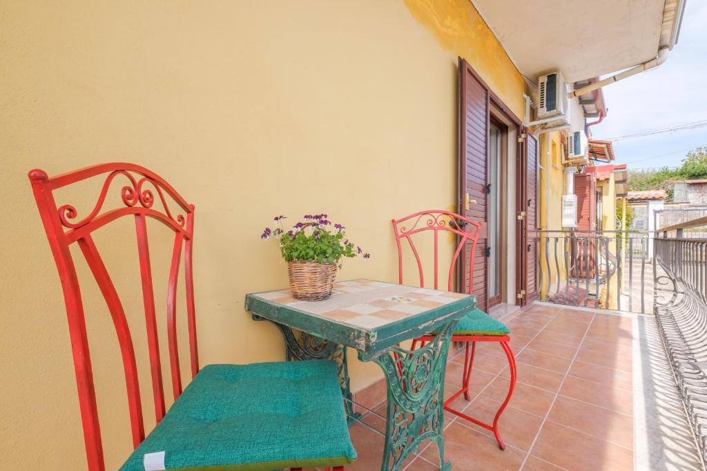 a small table and chairs on a balcony at Medusa Apartment in Taormina