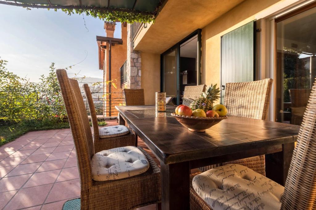 a wooden table with a bowl of fruit on a patio at Ferienwohnung Gardasee Castion in Castion Veronese