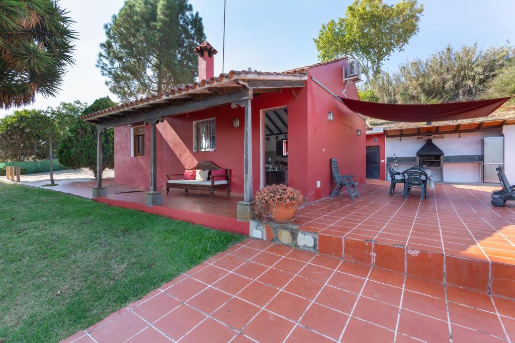a small red house with a patio at La Finca de Teror in Teror